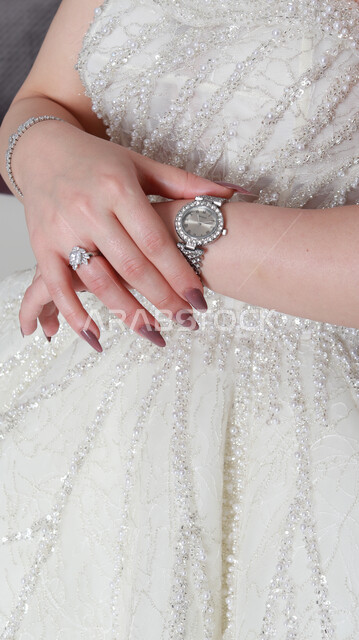 A close-up of a Saudi Arabian Gulf bride doing a photo session, holding a bride on her wedding day, a white wedding suit, a bouquet of roses, the night of her life, events and weddings.