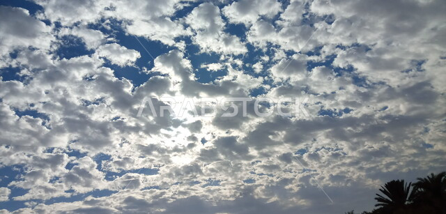 توهج أشعة الشمس بين الغيوم في السماء ، مناظر طبيعية خلابة في سماء المملكة العربية السعودية