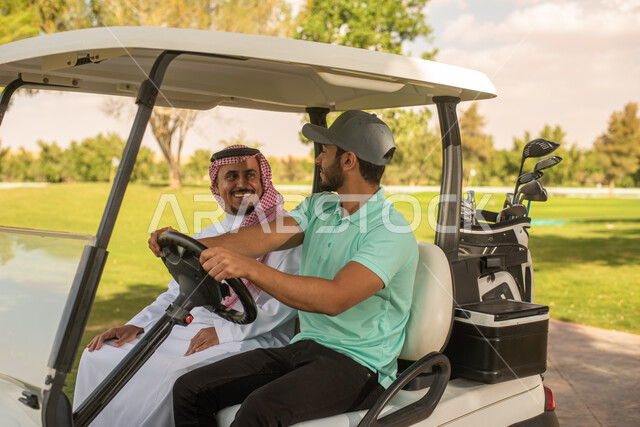 رجلان عربيان خليجيان سعوديان داخل سيارة كهربائية مختصة بنقل الركاب، لعبة الغولف، أنشطة رياضية في السعودية، رياضات الألعاب الأولمبية الصيفية، أنشطة ترفيهية، ملعب الجولف، نادي الجولف، عربة الجولف