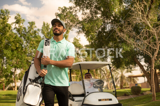 رجلان عربيان خليجيان سعوديان في ملعب الجولف، سيارة كهربائية مختصة بنقل الركاب، ممارسة لعبة الغولف، مساحات واسعة خضراء، أنشطة رياضية، لعبة الجولف، رياضات الألعاب الأولمبية الصيفية، أنشطة ترفيهية