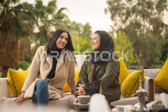 صديقتان عربيتان خليجيتان سعوديتان تستمتعان بتبادل الحديث، قضاء أوقات ممتعة، نقاشات وحوارات، صداقات وتعارف، الجلوس في الهواء الطلق، الطبيعة الخضراء