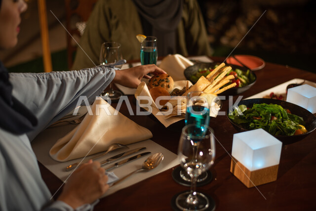 صورة مقربة لصديقتان عربيتان خليجيتان سعوديتان تستمتعان بتناول الطعام في احد المقاهي السعودية، قضاء أوقات ممتعة، المشروبات الباردة، أجواء سعيدة، مقهى سعودي
