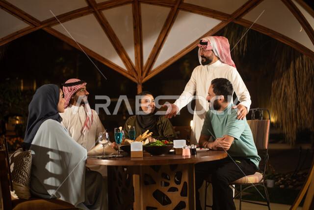 Saudi Gulf Arab friends enjoying an exchange of conversation in a Saudi cafe, people and acquaintance, a Saudi diwaniya, discussions and dialogues, cold drinks, spending enjoyable times, a happy atmosphere, a Saudi cafe