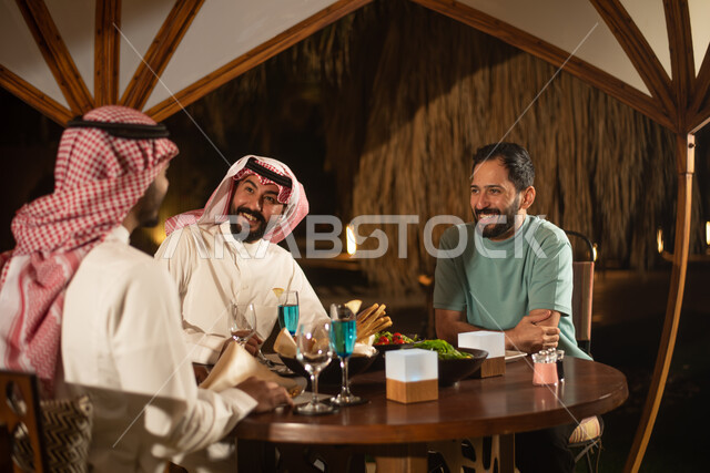 شباب عرب خليجيين سعوديين يستمتعون بتبادل الحديث في احد المقاهي السعودية، المشروبات الباردة، ديوانية شباب السعودية، قضاء اوقات ممتعة، نقاشات وحوارات، أجواء شبابية في مقهى سعودي