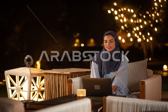 امرأة عربية خليجية سعودية تستخدم الحاسوب المحمول، العمل عن بعد، انجاز مهام العمل، تصفح الانترنت، استخدام تقنيات حديثة، حدائق ومنتزهات