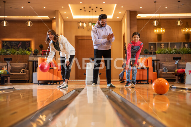 عائلة عربية  سعودية خليجية في  ملعب البولينج ،  أماكن ترفيهية ، ممارسة الأنشطة الرياضية الترفيهية  برفقة العائلة ، ممارسة لعبة البولينج ، مضمار البولينج ، التسلية والترفيه.