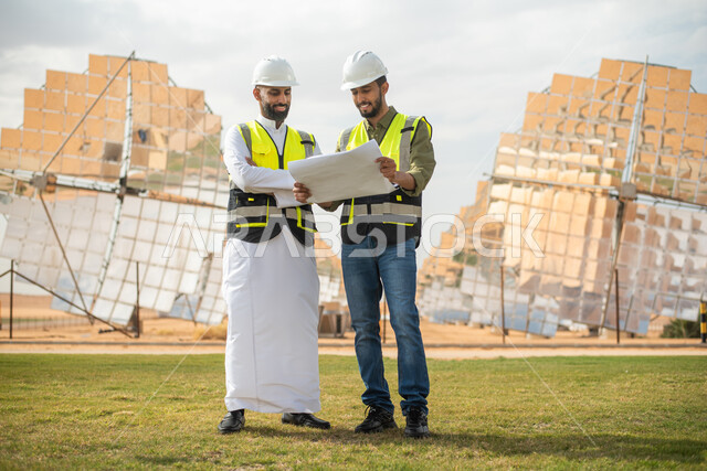 مهندسان طاقة عربيان خليجيان سعوديان يشرفان على محطات الطاقة الشمسية في السعودية، إرتداء خوذة وسترة الحماية الخاصة بالعمل، حوارات ونقاشات، مخططات وتصاميم هندسية، الطاقة المتجددة، الطاقة النظيفة، الطاقة الطبيعية، ستلايت، محطات الطاقة الشمسية