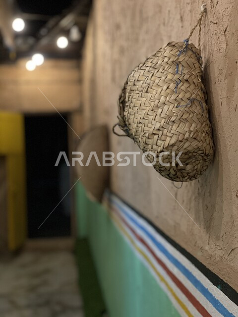 A straw basket hanging in a corridor inside one of the ancient heritage buildings, old popular houses, popularity