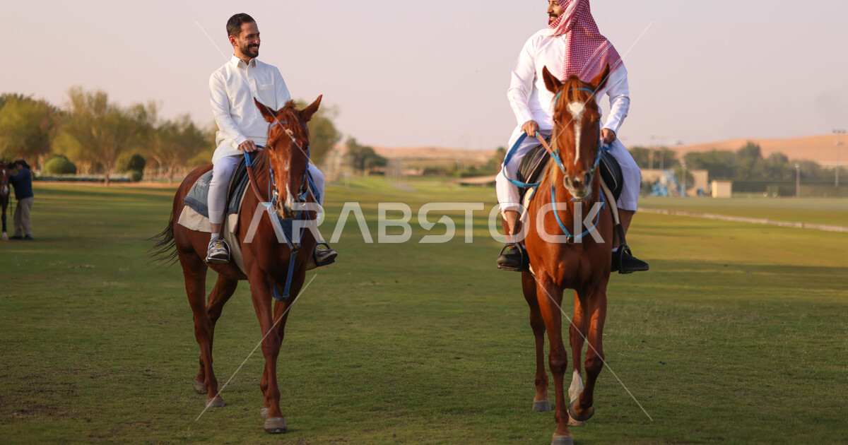 Two Saudi Arabian Gulf men riding horses, purebred Arabian horses