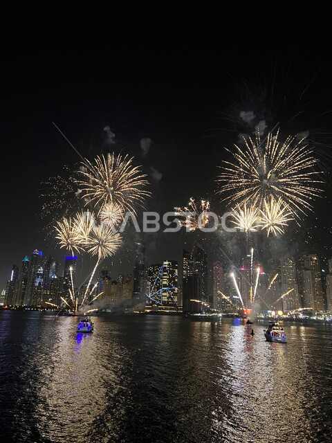 Celebration of fireworks at night, boats in the middle of the sea, celebrations, holidays and events, fireworks activities near buildings and skyscrapers, lighting colorful fireworks at night.