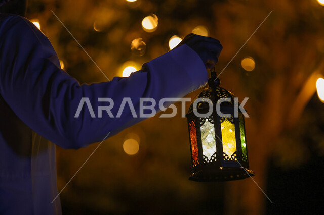 A close-up of a Saudi Arabian Gulf man holding a Ramadan lantern, Ramadan lantern, the blessed month of Ramadan, lighting and decorations for the month of Ramadan, Ramadan atmosphere, religious occasions