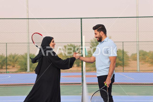 زوجان عربيان خليجيان سعوديان يتصافحان استعدادا لبدء لعب كرة المضرب، قضاء أوقات عائلية ممتعة، ممارسة كرة التنس الارضي، الملاعب العامة، ملعب رياضي، انشطة ترفيهية رياضية، العاب رياضية، اللعب والترفيه 