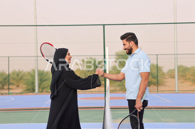زوجان عربيان خليجيان سعوديان يتصافحان استعدادا لبدء لعب كرة المضرب، قضاء أوقات عائلية ممتعة، ممارسة كرة التنس الارضي، الملاعب العامة، ملعب رياضي، انشطة ترفيهية رياضية، العاب رياضية، اللعب والترفيه 