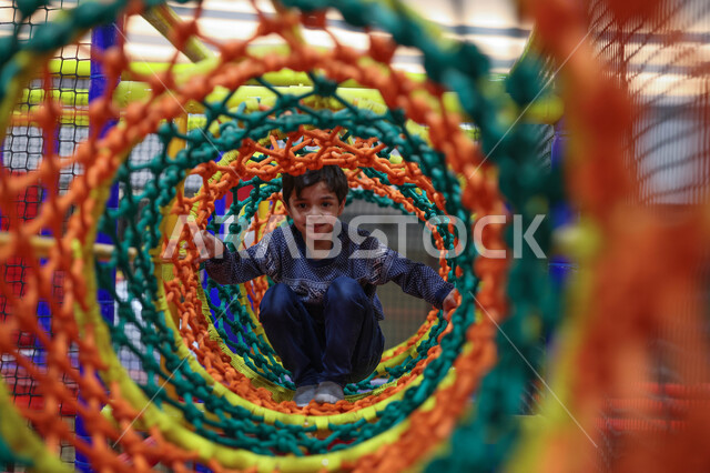 طفل عربي خليجي سعودي يستمتع باللعب، التسلية والترفيه، الانشطة الترفيهية، عطلة صيفية سعيدة، قضاء اوقات ممتعة، العاب الاطفال