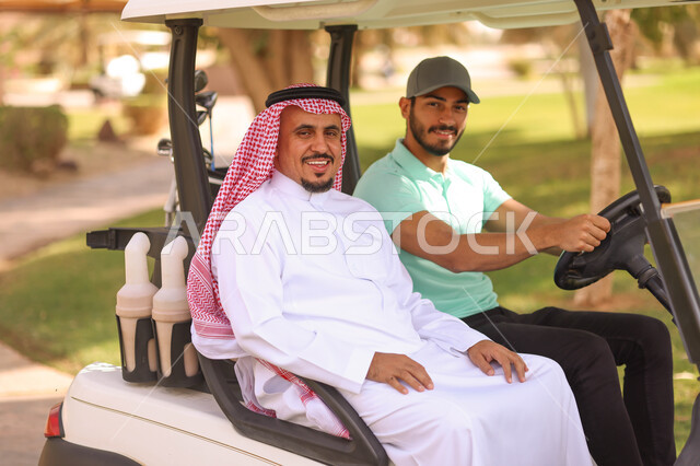 رجلان عربيان خليجيان سعوديان داخل سيارة كهربائية مختصة بنقل الركاب، لعبة الغولف ( الجولف ) ، أنشطة رياضية بالسعودية، رياضات الألعاب الأولمبية الصيفية، أنشطة ترفيهية، ملعب الجولف، نادي الجولف، عربة الجولف