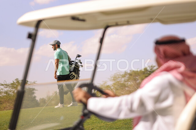 رجل عربي خليجي سعودي داخل سيارة كهربائية مختصة بنقل الركاب، ممارسة لعبة الغولف على مساحات واسعة خضراء، أنشطة رياضية بالسعودية، لعبة الجولف، رياضات الألعاب الأولمبية الصيفية، أنشطة ترفيهية، ملعب الجولف