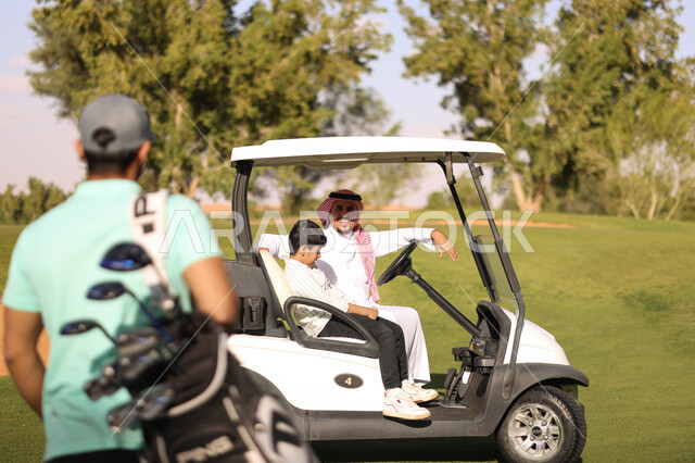 رجلان عربيان خليجيان سعوديان مع ولد صغير في ملعب الجولف، سيارة كهربائية مختصة بنقل الركاب، ممارسة لعبة الغولف على مساحات واسعة خضراء، أنشطة رياضية بالسعودية، لعبة الجولف، رياضات الألعاب الأولمبية الصيفية، أنشطة ترفيهية
