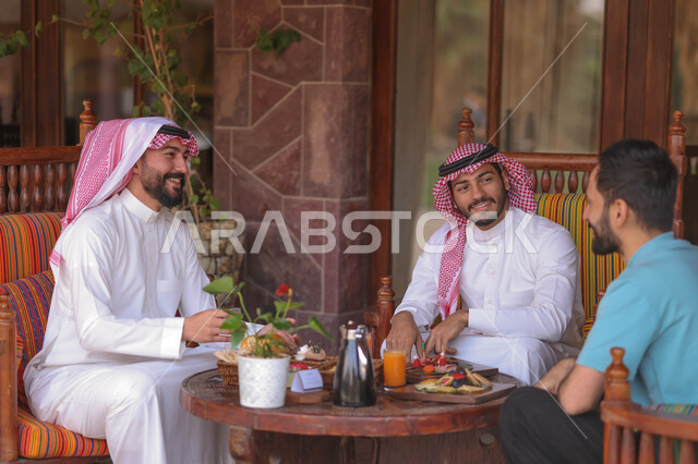 شباب عرب خليجيين سعوديين يستمتعون بتبادل الحديث في احد المقاهي السعودية، قضاء اوقات ممتعة، المشروبات الباردة، ديوانية شباب السعودية، نقاشات وحوارات، أجواء شبابية في مقهى سعودي