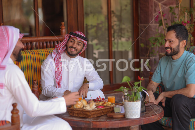 شباب عرب خليجيين سعوديين يستمتعون بتبادل الحديث في احد المقاهي السعودية، قضاء اوقات ممتعة، المشروبات الباردة، ديوانية شباب السعودية، نقاشات وحوارات، أجواء شبابية في مقهى سعودي