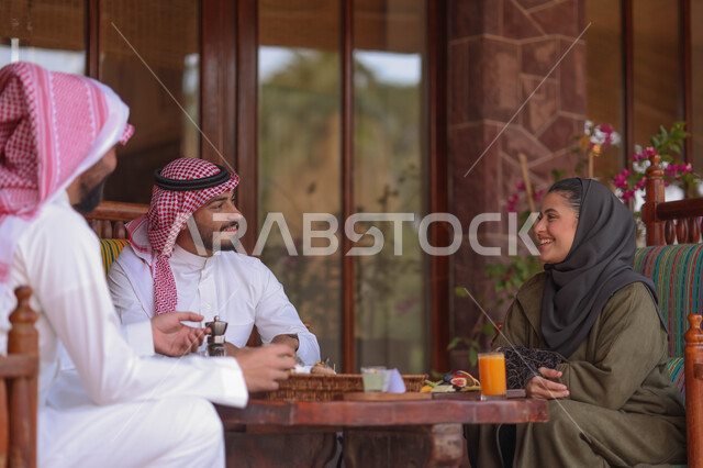 رجلان وامرأة عرب خليجيين سعوديين يستمتعون بتبادل الحديث في احد المقاهي السعودية، المشروبات الباردة، ديوانية سعودية، نقاشات وحوارات، قضاء أوقات ممتعة، وناسة وتعارف، مقهى سعودي