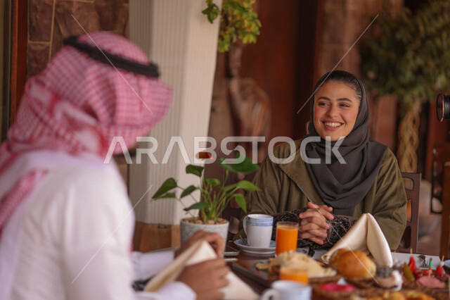 زوجان عربيان خليجيان سعوديان يستمتعان بتبادل الحديث  في احد المقاهي السعودية، تناول المشروبات الباردة، نقاشات وحوارات، قضاء أوقات ممتعة، أجواء عائلية سعيدة، مقهى سعودي