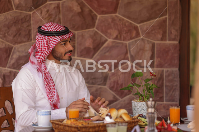 رجل عربي خليجي سعودي يقضي اوقات ممتعة في احد المقاهي السعودية، المشروبات الباردة، أنشطة شبابية ترفيهية، الجلوس في المقهى، أجواء سعيدة، مقهى سعودي