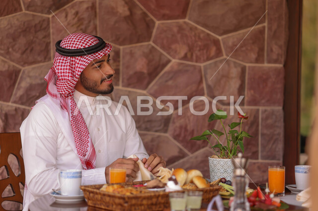 رجل عربي خليجي سعودي يقضي اوقات ممتعة في احد المقاهي السعودية، المشروبات الباردة، أنشطة شبابية ترفيهية، الجلوس في المقهى، أجواء سعيدة، مقهى سعودي
