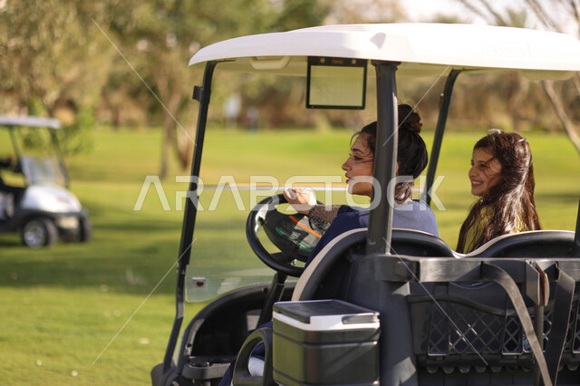 فتاتان عربيتان خليجيتان سعوديتان داخل سيارة كهربائية مختصة بنقل الركاب، لعبة الغولف ( الجولف ) ، أنشطة رياضية بالسعودية، رياضات الألعاب الأولمبية الصيفية، أنشطة ترفيهية، ملعب الجولف، نادي الجولف