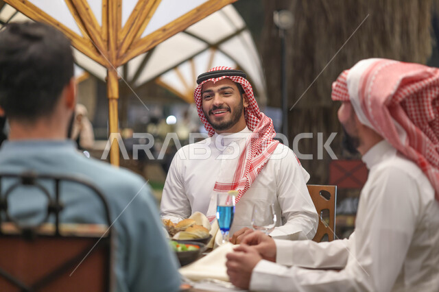 شباب عرب خليجيين سعوديين يستمتعون بتبادل الحديث في احد المقاهي السعودية، قضاء اوقات ممتعة، المشروبات الباردة، ديوانية شباب السعودية، نقاشات وحوارات، أجواء شبابية في مقهى سعودي