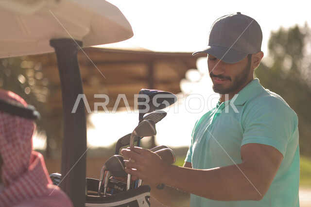 رجل عربي خليجي سعودي في ملعب الجولف، الإستعداد لممارسة لعبة الغولف، حقيبة الجولف، أنشطة رياضية بالسعودية، لعبة الغولف ( الجولف ) ، رياضات الألعاب الأولمبية الصيفية، أنشطة ترفيهية، ملعب الجولف