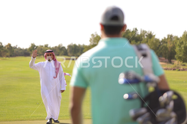 رجلان عربيان خليجيان سعوديان في ملعب الجولف، ممارسة لعبة الغولف على مساحات واسعة خضراء، أنشطة رياضية بالسعودية، لعبة الجولف، رياضات الألعاب الأولمبية الصيفية، أنشطة ترفيهية، ملعب الجولف