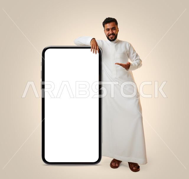 بورتريه لشاب عربي خليجي سعودي يقوم بعرض جهاز الهاتف المحمول بإيماءات مختلفة ، الحصول على الهدف المراد ، التسويق الرقمي ، اعلانات تسويقية ترويجية ، تطبيقات الهاتف الذكي , استخدام التقنية الحديثة , خلفية بيضاء .
