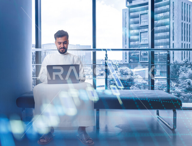 رجل عربي خليجي سعودي يستخدم الحاسوب المحمول، إنجاز مهام العمل، تصفح الإنترنت، العمل عن بعد، التسويق الإلكتروني , رسومات بيانية , البورصة , استخدام الأجهزة الابكترونية . 