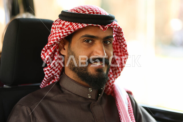 رجل عربي خليجي سعودي يجلس في إحدى وسائل النقل العامه, رحله ممتعه، نزهه في الهواء الطلق، النظر الى الكاميرا, التنقل في وسائل المواصلات, جوله سياحيه