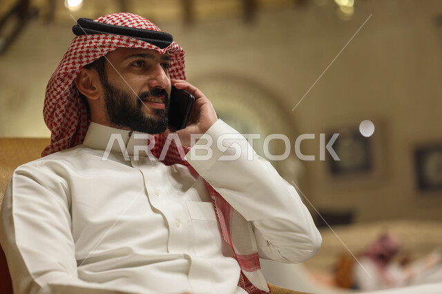 رجل عربي خليجي سعودي يقوم بإجراء مكالمة هاتفية، التواصل مع الأفراد، اتصال وتواصل، علاقات اجتماعية، دردشة وتعارف، التواصل الإجتماعي، جلسة سعودية