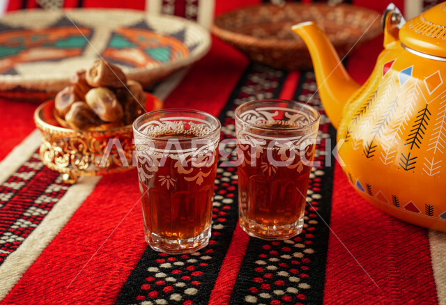 إبريق شاي اصفر اللون مع اكواب الشاي، المشروبات الساخنة، تقديم الشاي، طبق التمر، حسن الضيافة والاستقبال، الضيافة العربية