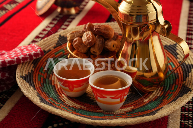 Arabic coffee dallah with two cups of coffee, dates dish, serving hot coffee, Saudi hospitality, Arabic coffee, good hospitality and reception, Ramadan, holidays and occasions