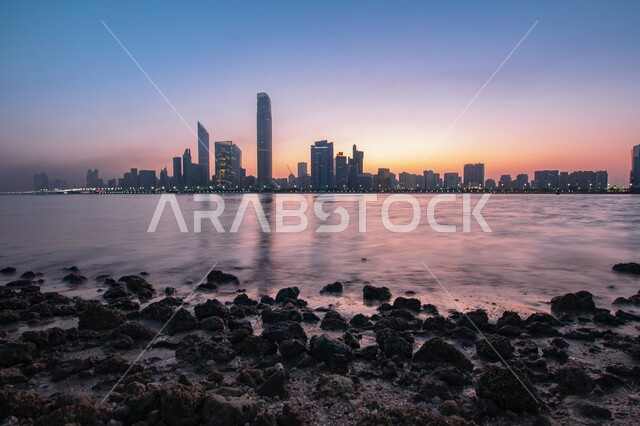 شاطئ البحر في مدينة ابو ظبي بالامارات العربية المتحدة وقت غروب الشمس، الابراج وناطحات السحاب، هدوء البحر، معالم ابو ظبي، السياحة في الامارات