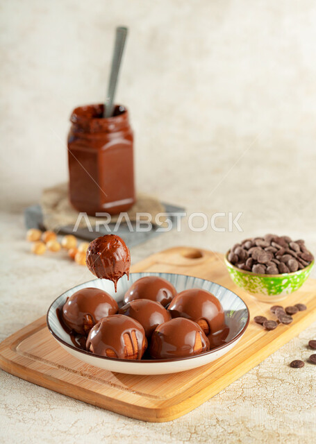 A plate of luqaimat sweets with liquid chocolate, balls covered with chocolate, sweets and sugars