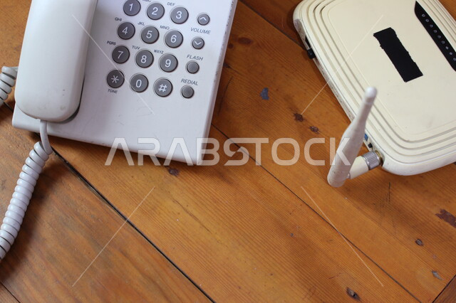 صورة مقربة لجهاز التوجيه الشبكي، تيلفون، موجه شبكات، جهاز الواي فاي، اجهزة تقنية حديثة، هاتف ارضي، اجهزة شبكية، طاولة خشبية