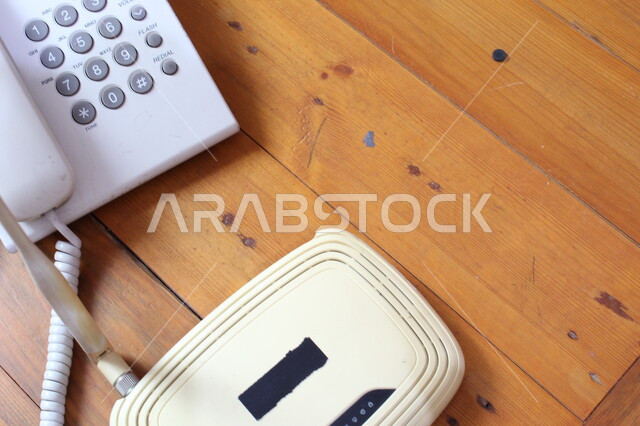 صورة مقربة لجهاز التوجيه الشبكي، تيلفون، موجه شبكات، جهاز الواي فاي، اجهزة تقنية حديثة، هاتف ارضي، اجهزة شبكية، طاولة خشبية