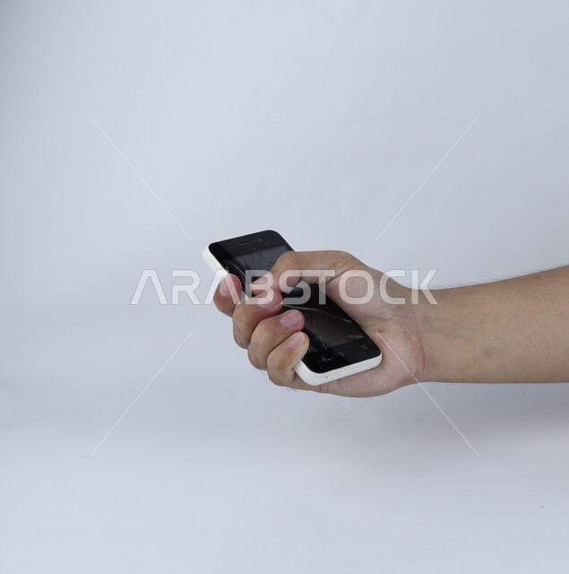 يد تحمل الهاتف المحمول ، الهاتف الخلوي بشاشة مكسورة ، خلفية بيضاء