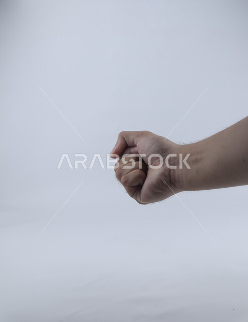 قبضة اليد على خلفية بيضاء ، مفهوم لغة الإشارة ، وسيلة تواصل غير صوتية ، دلالة على الغضب ، لكمة وقتال