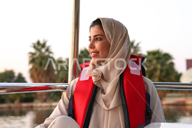 صورة مقربة لامرأة عربية خليجية سعودية تقضي اوقات ممتعة في احد الاماكن السياحية الترفيهية، ركوب قارب في بحيرة مائية، بركة مائية، أنشطة ترفيهية، نزهه في الهواء الطلق