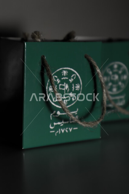 A close-up of founding day gift bags, founding day distributions, national celebrations, the anniversary of the founding of the first Saudi state 1727 AD, fat day, green paper bags