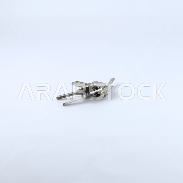 صورة مقربة لمجموعة من المفاتيح ، مفاتيح معدنية ,قفل الابواب, خلفيه بيضاء