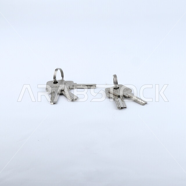 صورة مقربة لمجموعة من المفاتيح ، مفاتيح معدنية ,قفل الابواب, خلفيه بيضاء