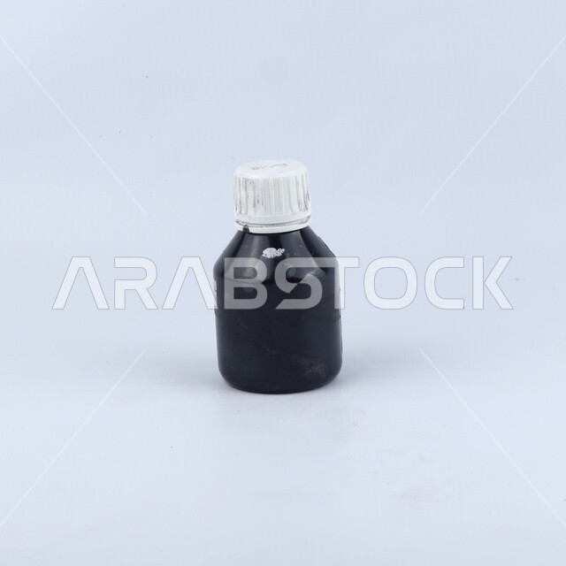 علبه زجاجيه مليئه بالحبر السائل, علبة حبر, قرطاسيه, حبر أسود, أدوات مكتبيه, خلفيه بيضاء