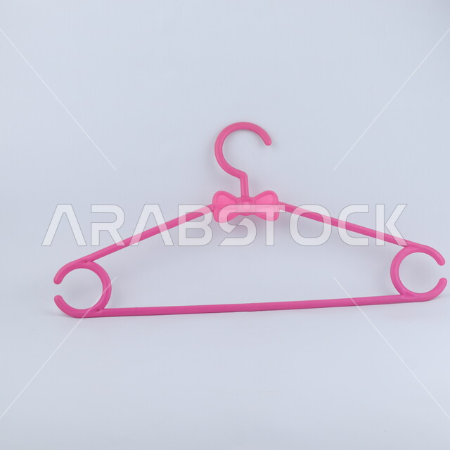 علاقة ملابس من البلاستيك, تعليقة ملابس باللون الوردي, خلفيه بيضاء