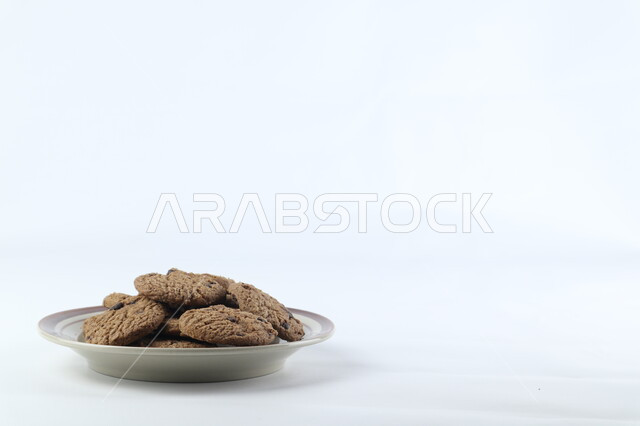 A plate of chocolate chips, crispy chips, cookies, chocolate biscuits, freshly baked sweets, white background